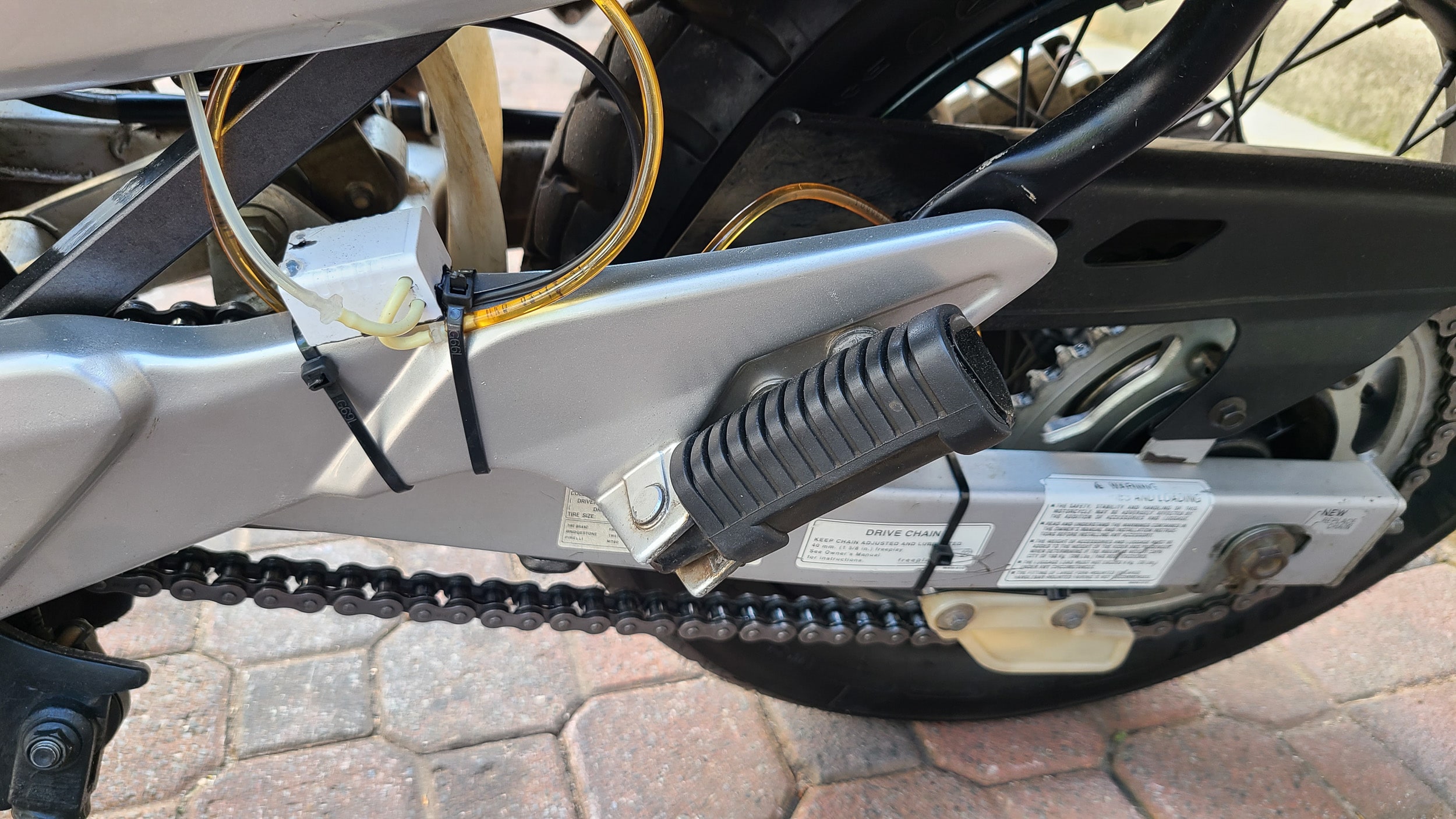 a plastic box with hoses attached to the swingarm