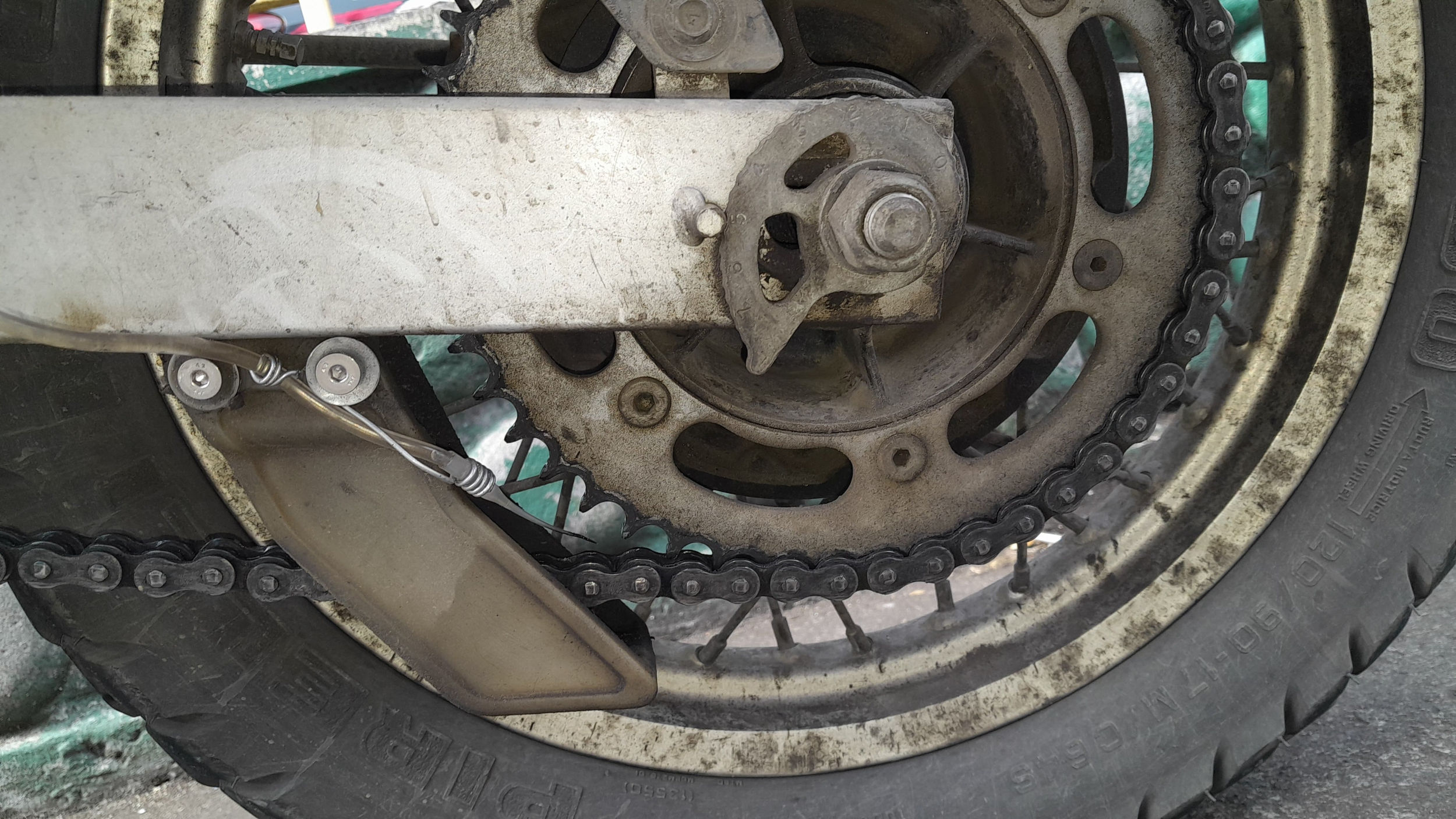 a hose and nozzle held near the rear sprocket with a wire