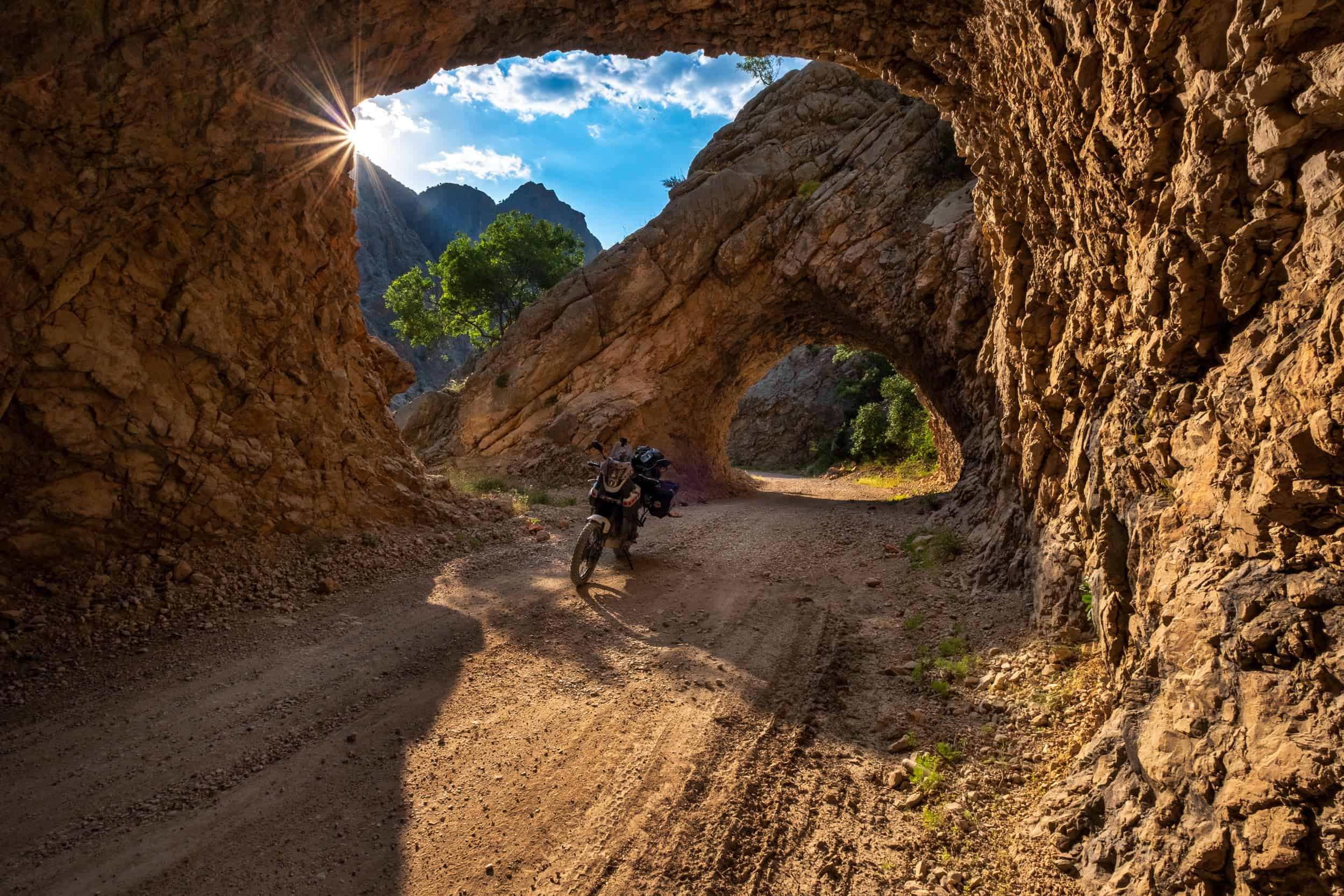 motorcycle btween two tunnels through a canyon at sunrise