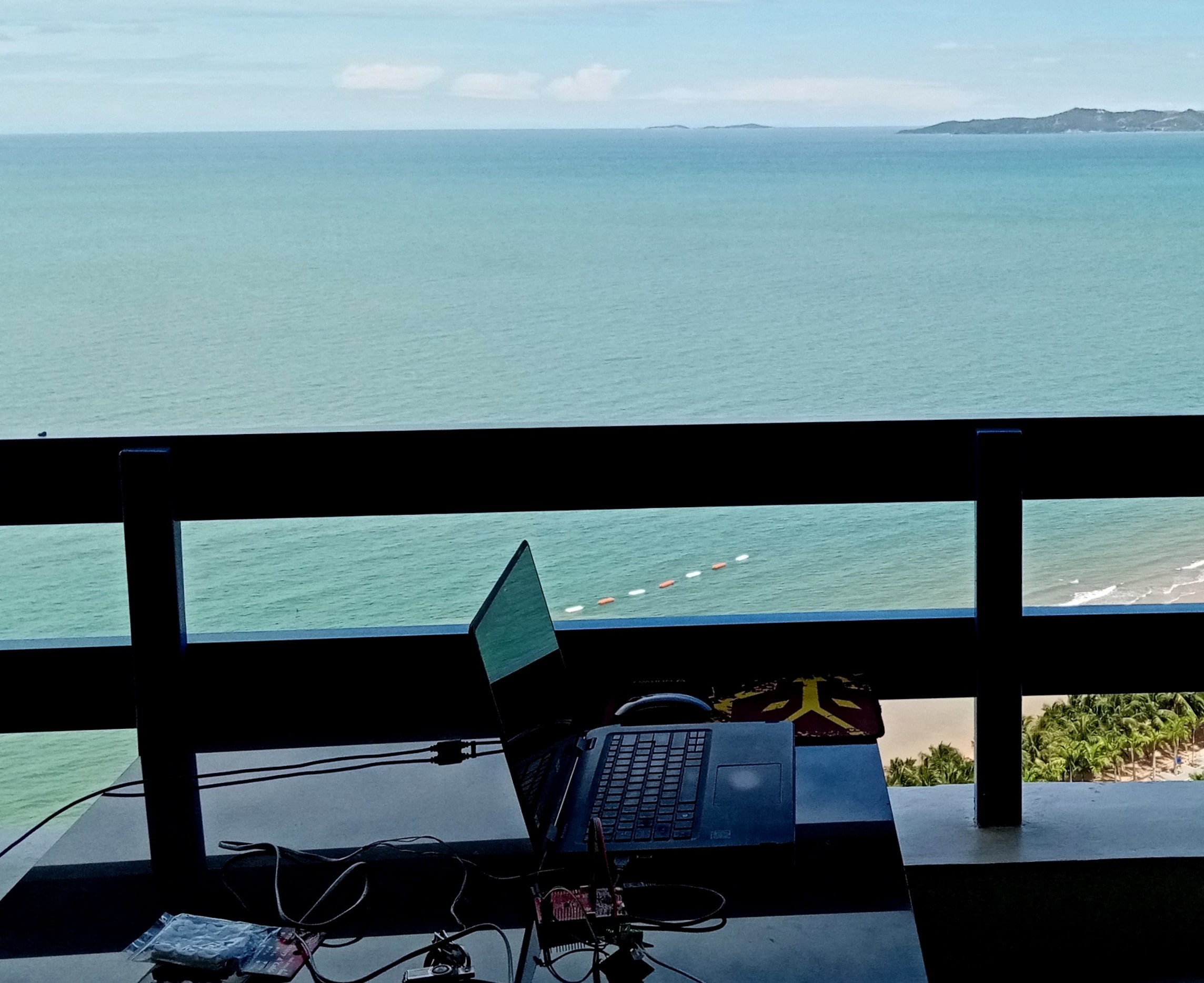 elecytronics boards and a computer on a table overlooking ocean