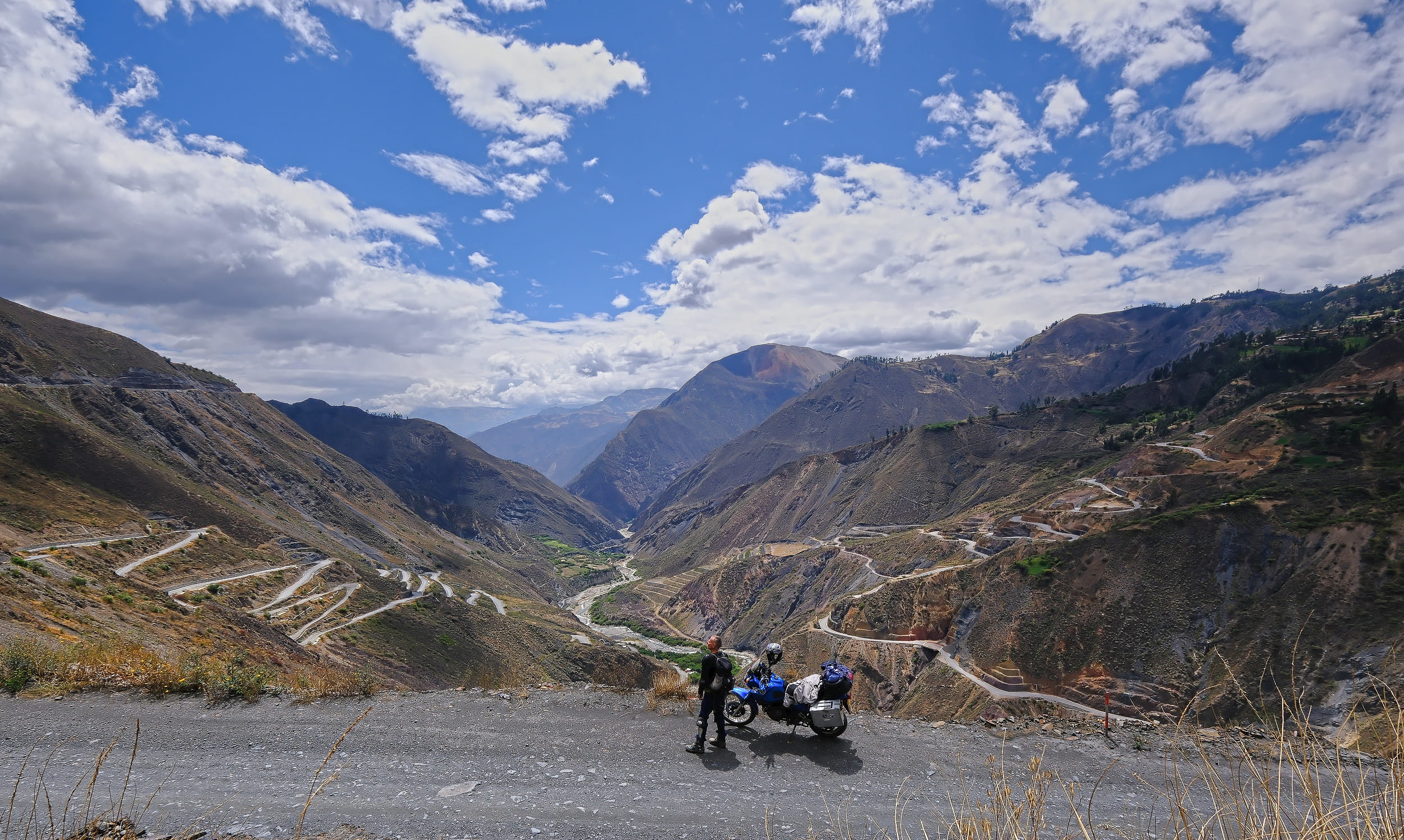 motorcycle and rider high above a canyon with switchbacks on both sides