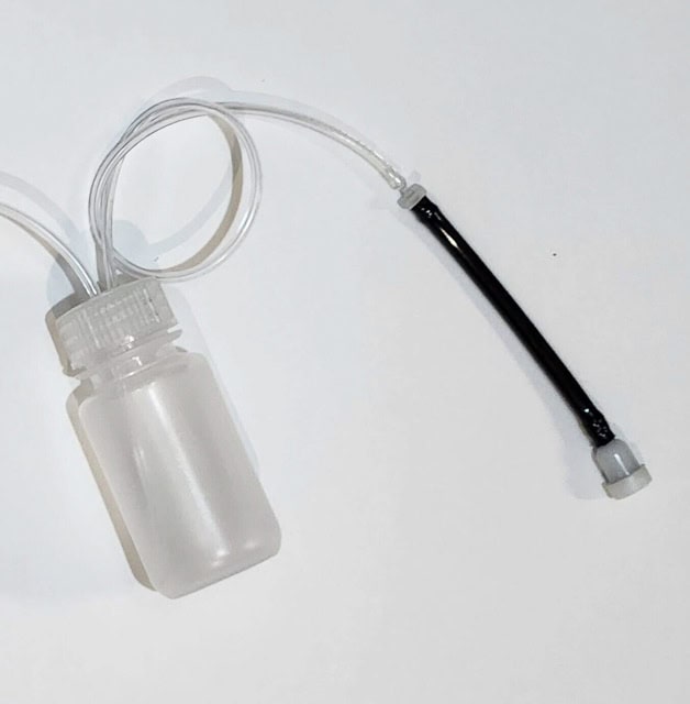 plastic bottle vith a hose connected to a breather valve
