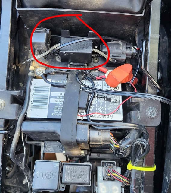 plastic electronics box attached to the plastic under the motorcycle seat