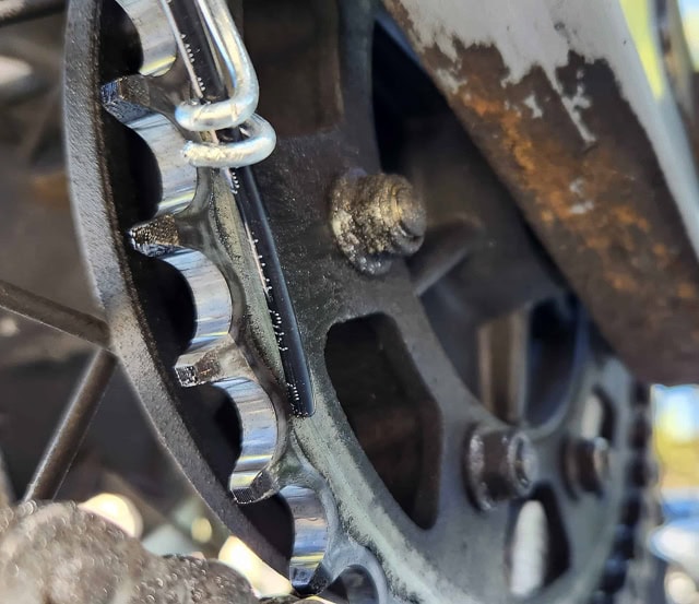 photo of a wire loop away from the sprocket holding hose in place