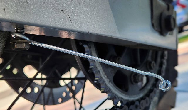 photo of a loose bolt holding  wire loop at the bottom of a swingarm